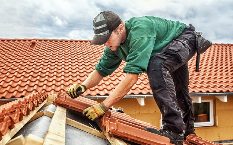 Artisan couvreur professionnel à Toulouse effectuant des travaux sur une toiture en tuiles